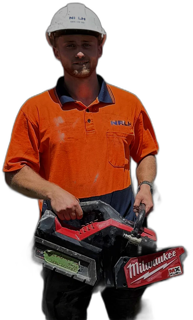 An NRLH labourer in a white hard hat and orange shirt, holding a demolition saw